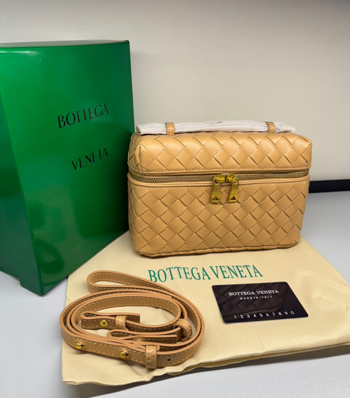 Bott ega Ven eta handbag with matching belt and green box on a white background