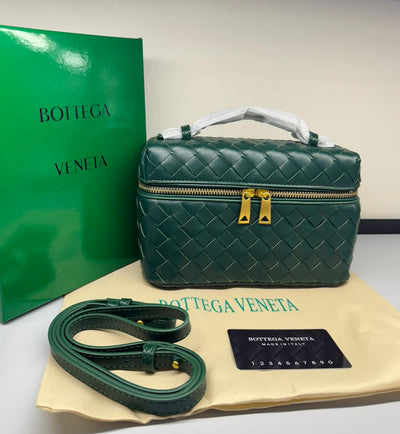 Green woven handbag with matching strap and dust bag on a white surface, featuring Bot tega Ven eta branding.