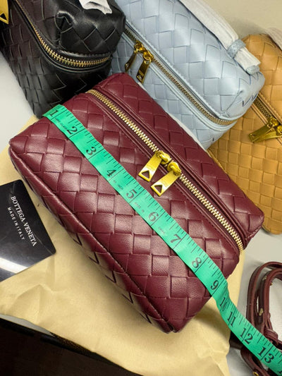 Maroon quilted handbag with gold zipper and measuring tape, Bot tega Ven eta card visible