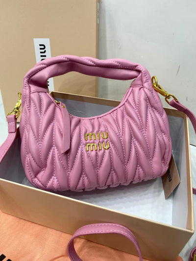 Pink quilted handbag with 'mi-u mi-u' logo in a box