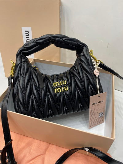 Black handbag with gold logo on a white background