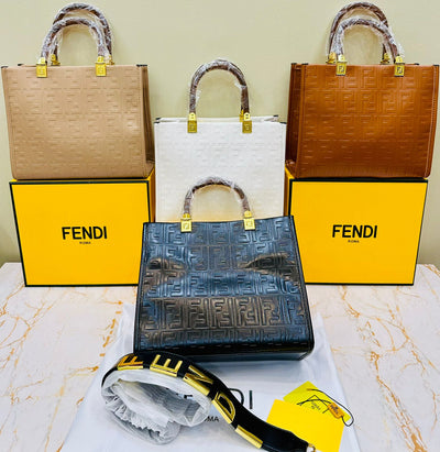 Fen di handbags displayed with branded boxes on a marble surface