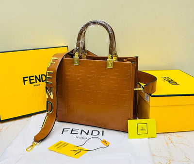 Fen di handbag with yellow strap and packaging on a light background