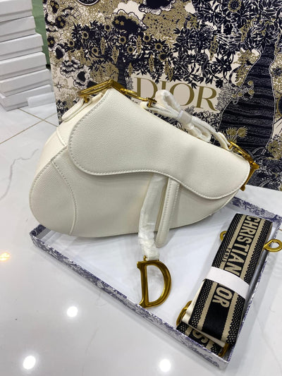 White handbag with gold accents on a Di or branded box