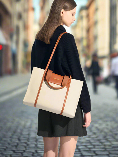 Woman carrying a beige tote bag with brown accents on a white background