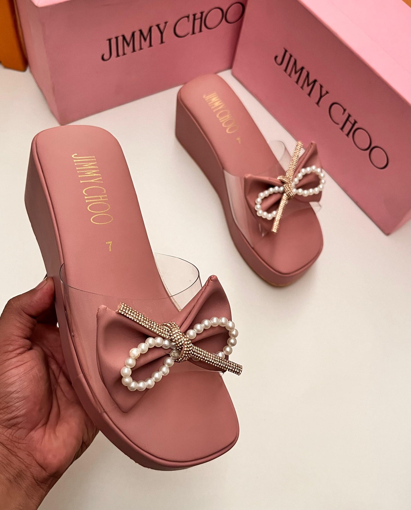 Pink Jim my Ch oo sandals with pearl bows on a white background